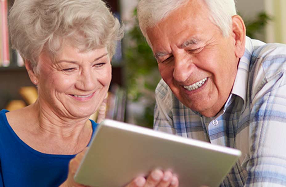 Two seniors look at a tablet together