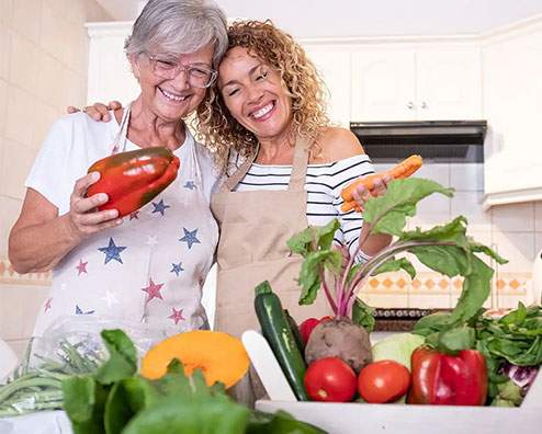 two women with a table of vegetables