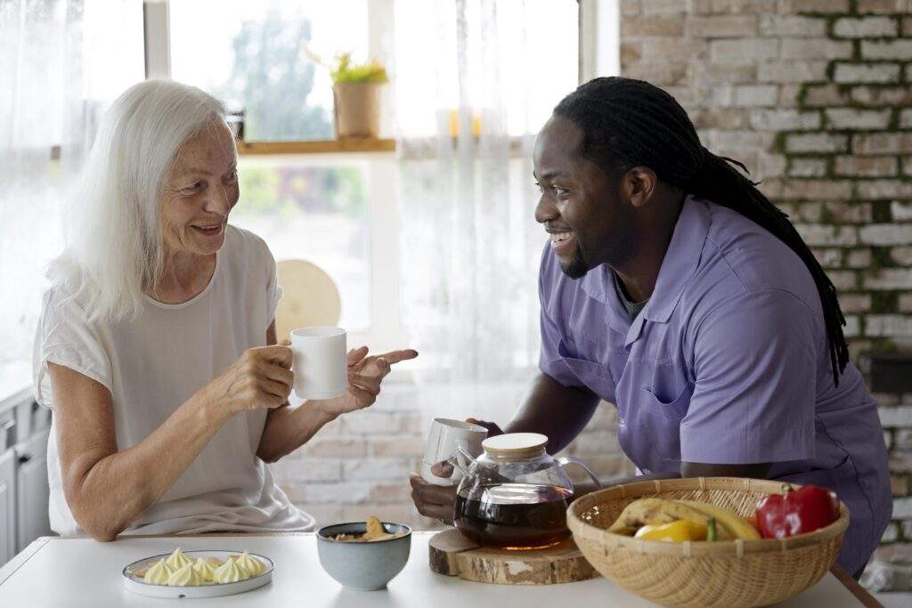 Caregiver providing personal care assistance to elderly women over a meal 
