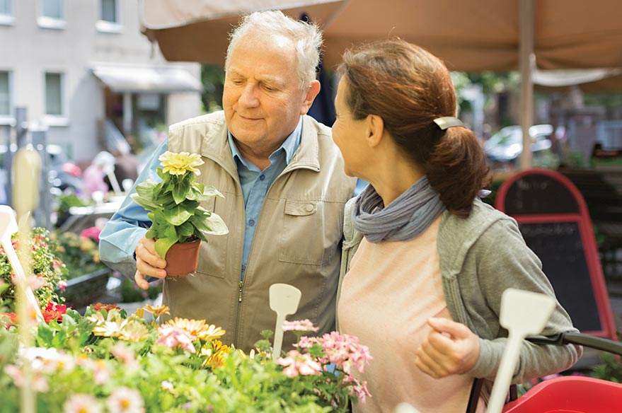 A caregiver helps a client choose plants at a nursery