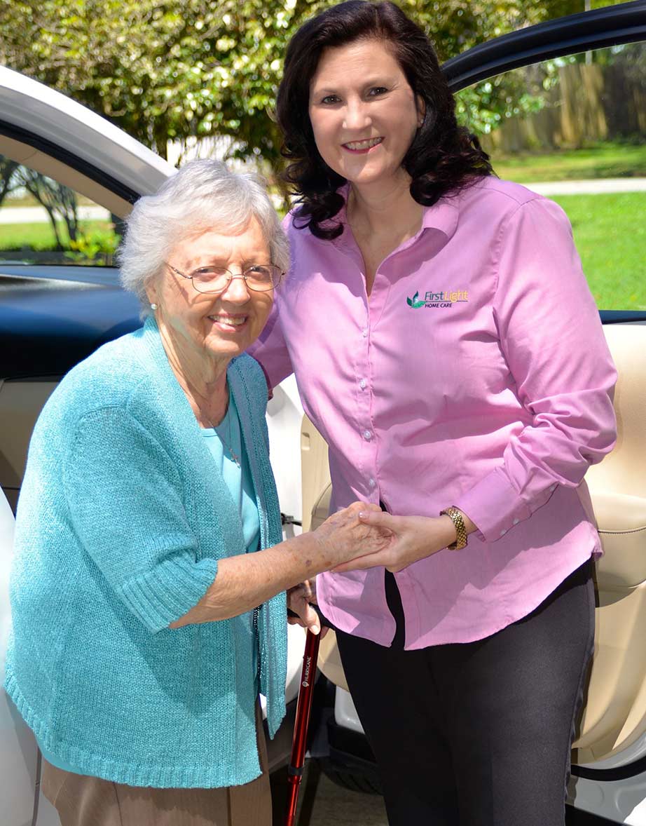 A FirstLight Home Care of Kenosha caregiver helps a senior client out of a car