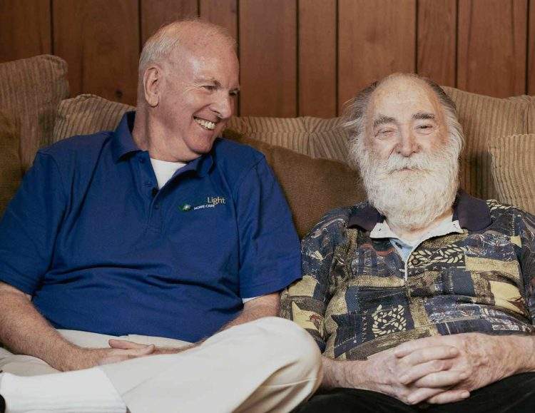 FirstLight Caregiver of the Year Brian sits and laughs with a client