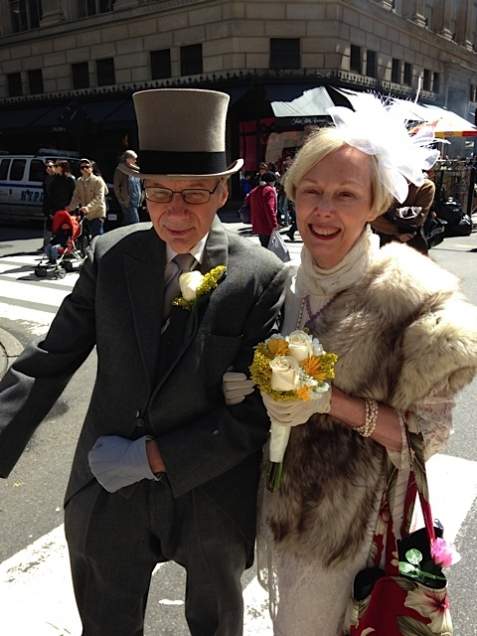 A senior couple dressed up in their finest outfits, standing on the street of Manhattan