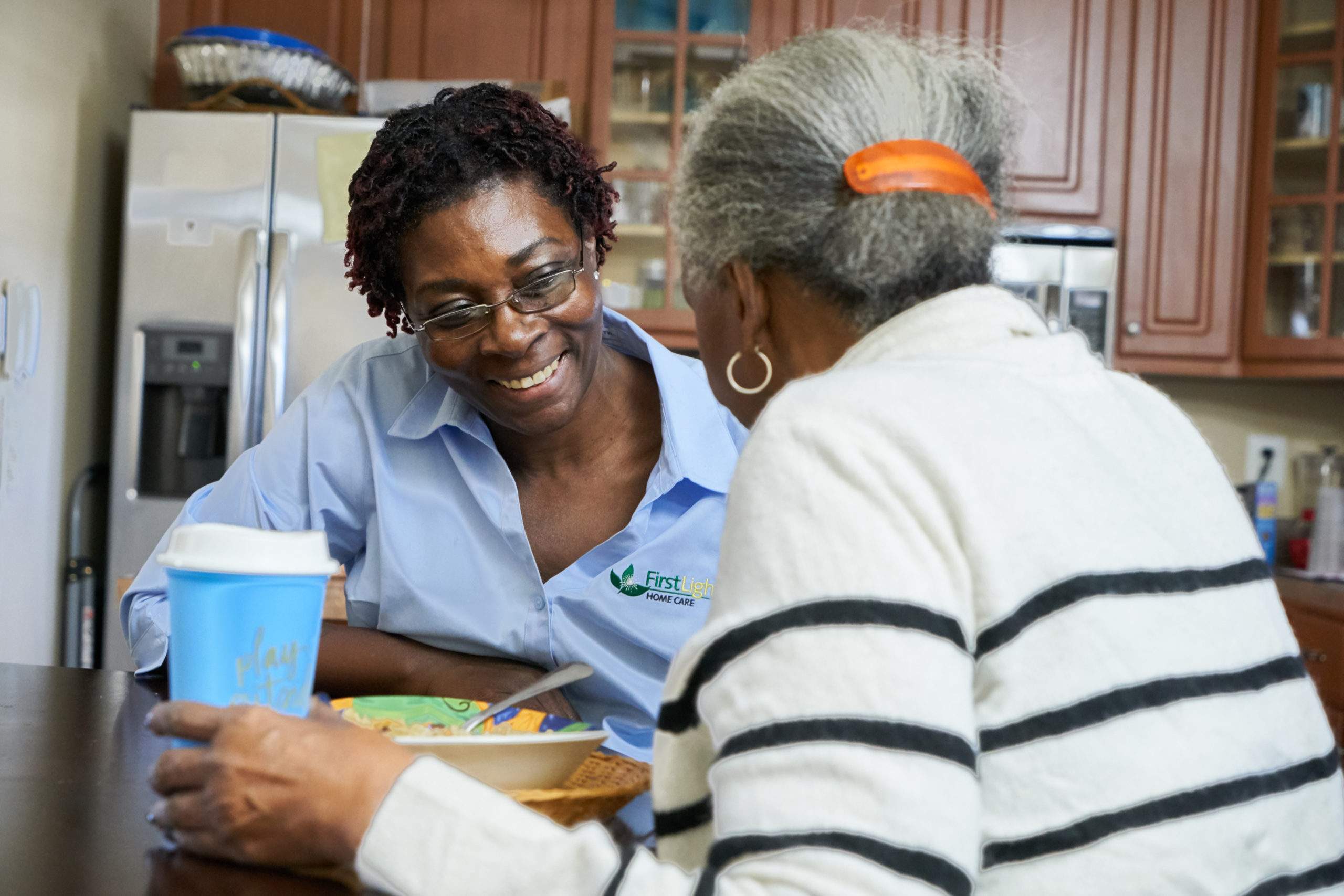 FirstLight caregiver Cynthia talking, laughing and smiling with client