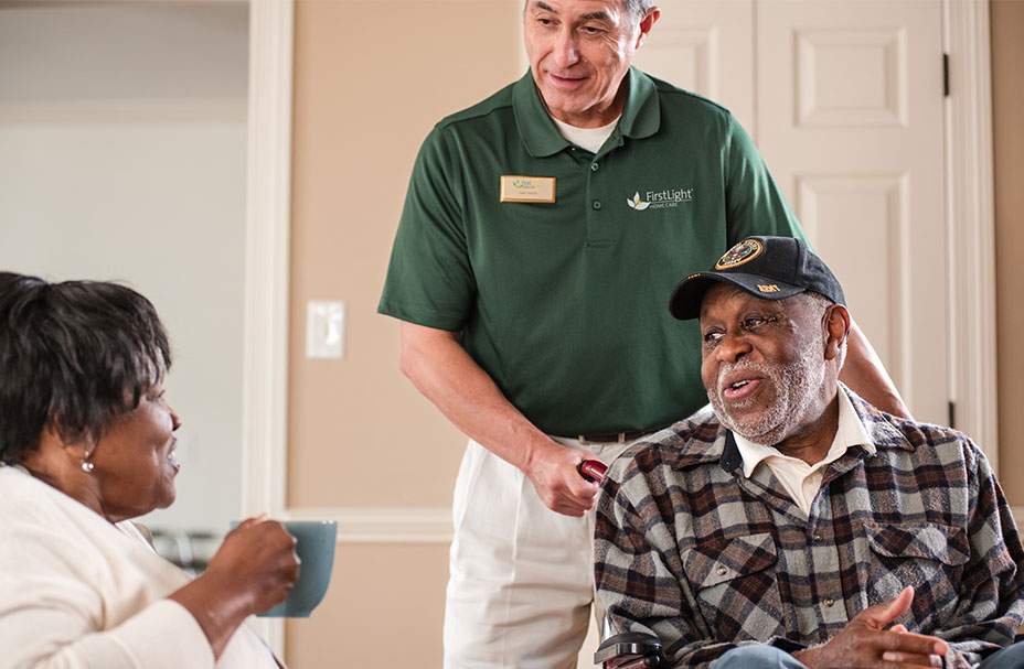 man in wheelchair with an aid and woman