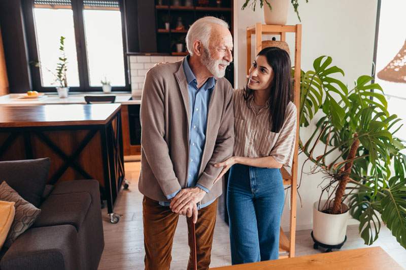 Caregiver assisting older man in his home