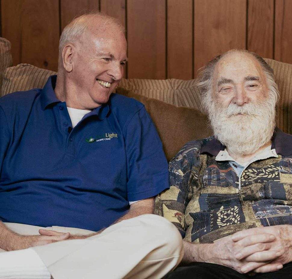 FirstLight Caregiver of the Year Brian sits and laughs with a client