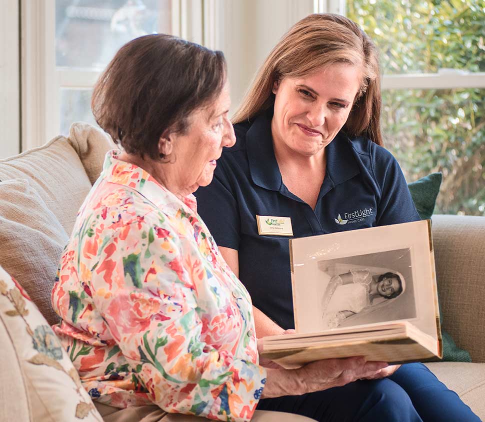 older woman and caretaking looking at an album