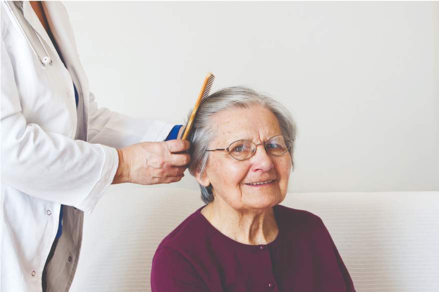 An elderly woman getting a haircut