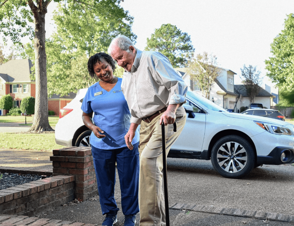 aid helping older man with a walker