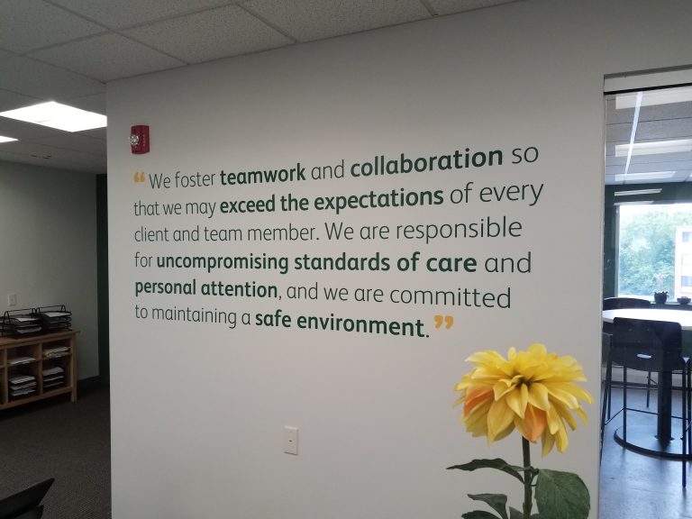 A wall in FirstLight's office showing their mantra: We foster teamwork and collaboration so that we may exceed expectations of every client and team member.