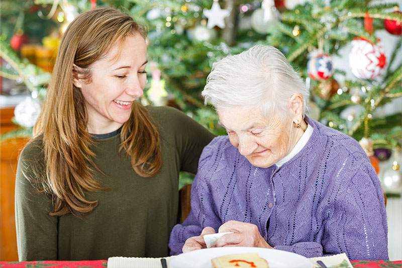 A woman assists an elderly woman.