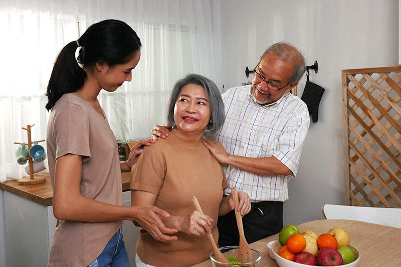 older couple and younger women cooking