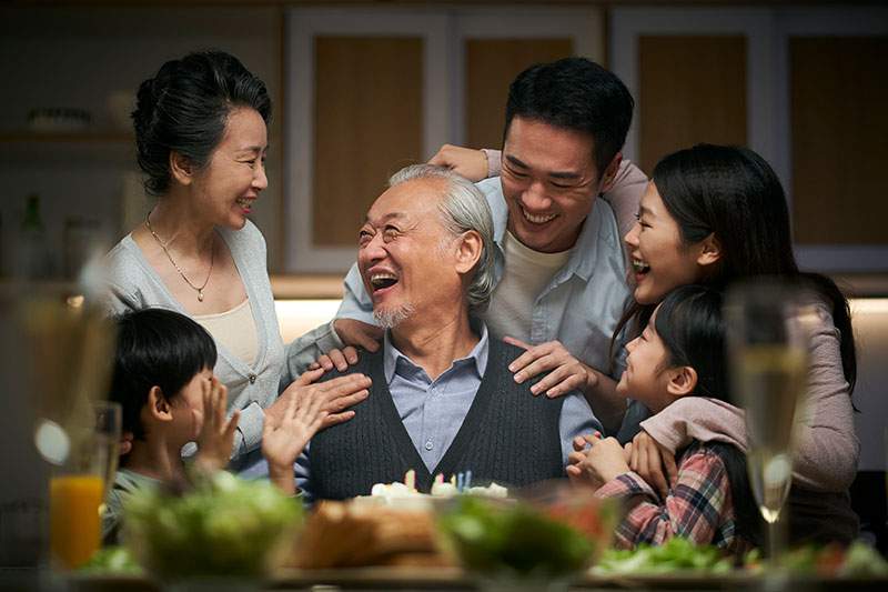 An Asian family laughing and smiling together