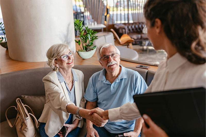 elderly couple taking to someone with a tablet