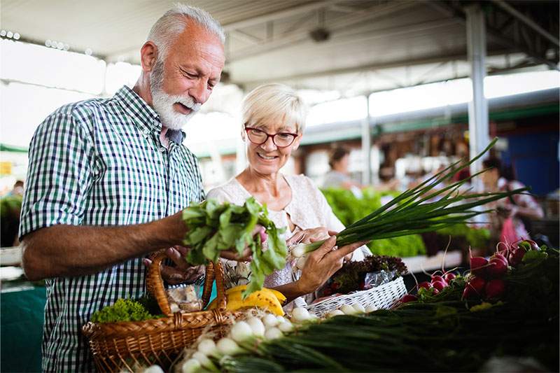 Older couple buying vegetables