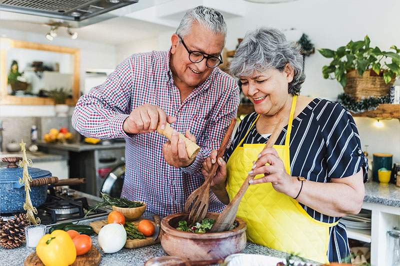 older couple making a salad