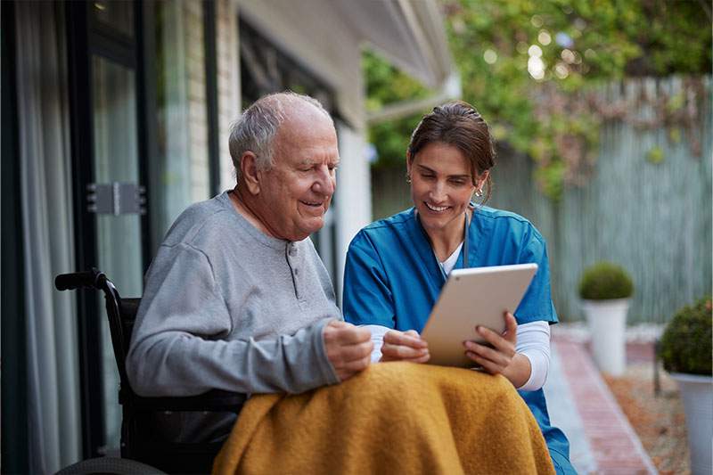 elderly man in a wheelchair and a caregiver