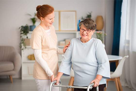 A caregiver assists a client using a walker