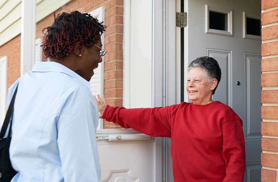 A client meets a caregiver at her front door