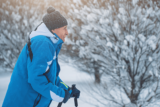 senior with blue coat in snow. senior winter safety tips