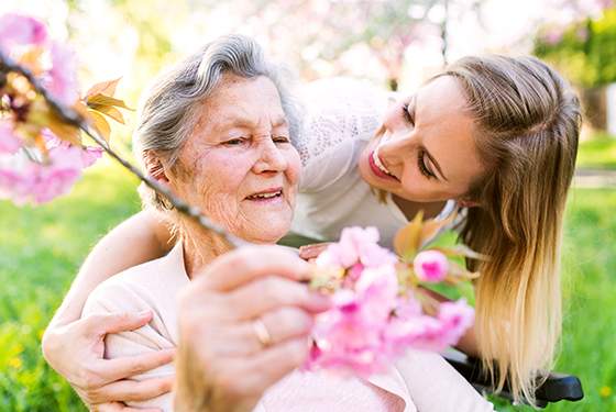 senior spring activities, elderly women and her cargiver during spring outside.