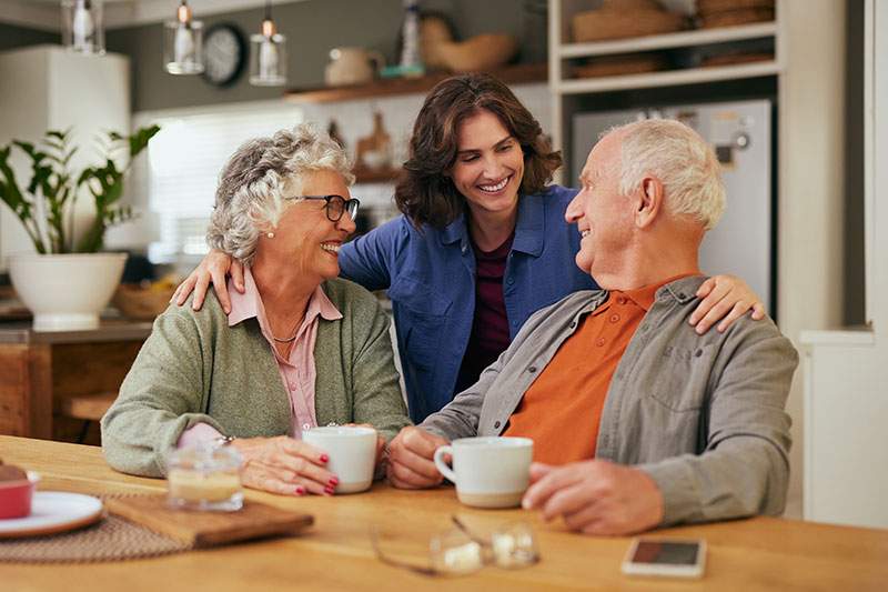 older couple having coffee with a younger woman