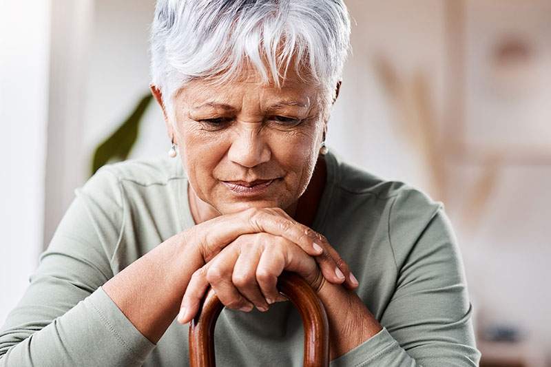 older woman with her head on her hands