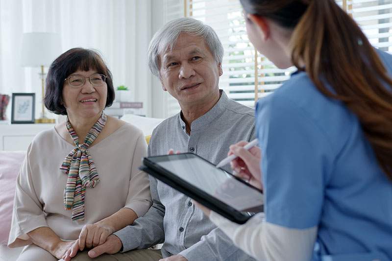 A doctor talking with an elderly couple in a medical office