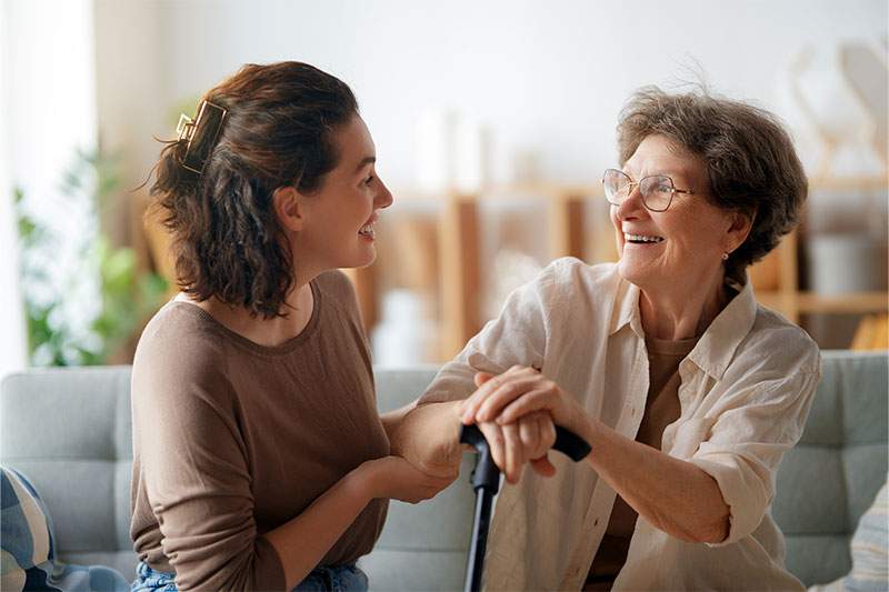 A woman engages in conversation with an older woman.