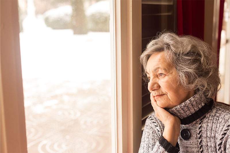older woman looking out the window